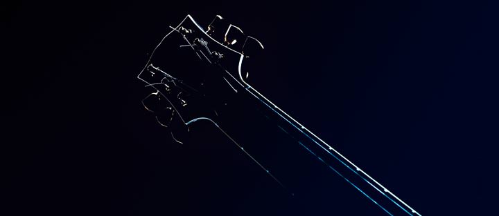 Eine Gitarre vor einem schwarzen Hintergrund.