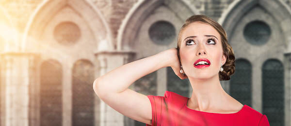 Frau hält sich vor einer Kirche die Ohren zu.