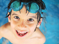Kind spiel im Schwimmbad mit Auquafit Junior Stöpseln im Ohr.