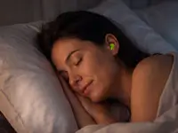 Eine Frau schläft friedlich in ihrem Bett und trägt grüne Snugos Silikon-Ohrstöpsel zur Geräuschdämmung.