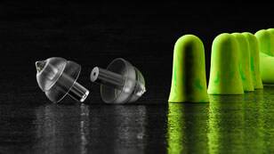 Ein Paar Gehörschutz und grüne Schaumstoffstöpsel
