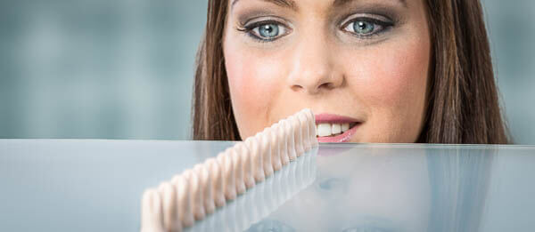 Eine Frau schaut über beigefarbene Gehörschutzstöpsel